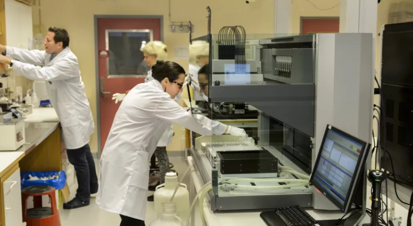 Två kvinnor och en man klädda i vita labbrockar arbetar i ett laboratorie på avdelningen Onkologi på Medicon Village. Foto. Fotograf: Kennet Ruona